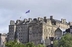 Panoramic view of Edinburgh's historic rooftop architecture under blue skies.
