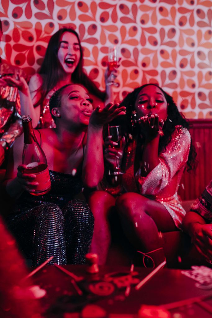 Adults celebrating with drinks, disco vibe, capturing fun and joy in a festive indoor setting.